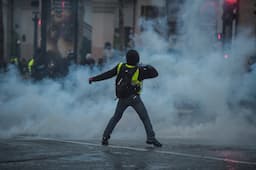 <p>A protestor wearing a yellow vests (gilets jaunes) reacts amid tear gas during a demonstration near the Champs Elysees Avenue in Paris, on December 15, 2018, to protest against rising costs of living they blame on high taxes. &#8211; The &#8220;Yellow Vests&#8221; (Gilets Jaunes) movement in France originally started as a protest about planned fuel hikes but has morphed into a mass protest against President&#8217;s policies and top-down style of governing. (Photo by Lucas BARIOULET / AFP)</p>
